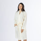Mid-length front view of a model wearing the ivory textured stripe robe, showing the wrap front, tie belt, long sleeves and front pocket detail.