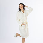 Full-length posed view of a model wearing the ivory textured stripe robe with one hand in the pocket and one leg raised, shown on a white background.