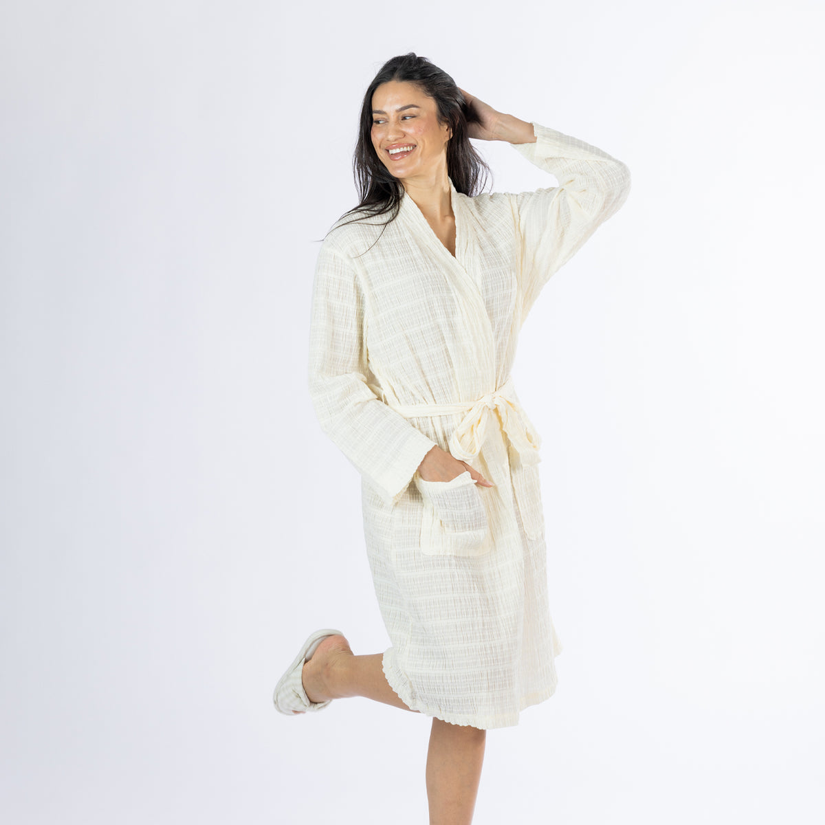 Full-length posed view of a model wearing the ivory textured stripe robe with one hand in the pocket and one leg raised, shown on a white background.