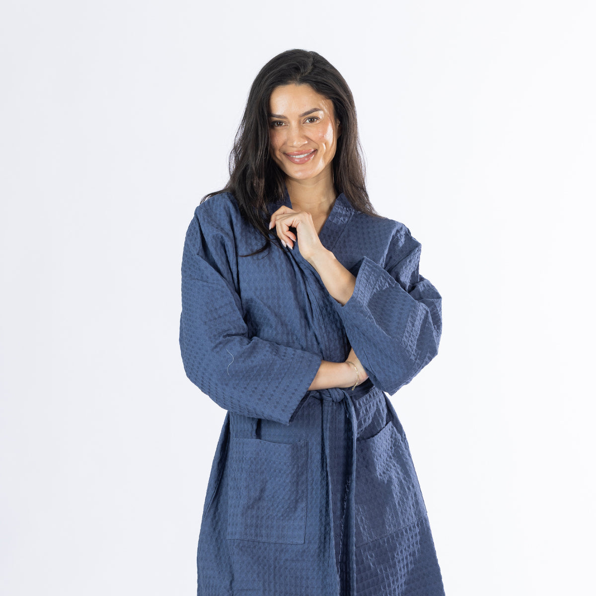 Model wearing an indigo Cove Dilys Waffle Bathrobe with a wrap-front design, long sleeves and waist tie belt.
