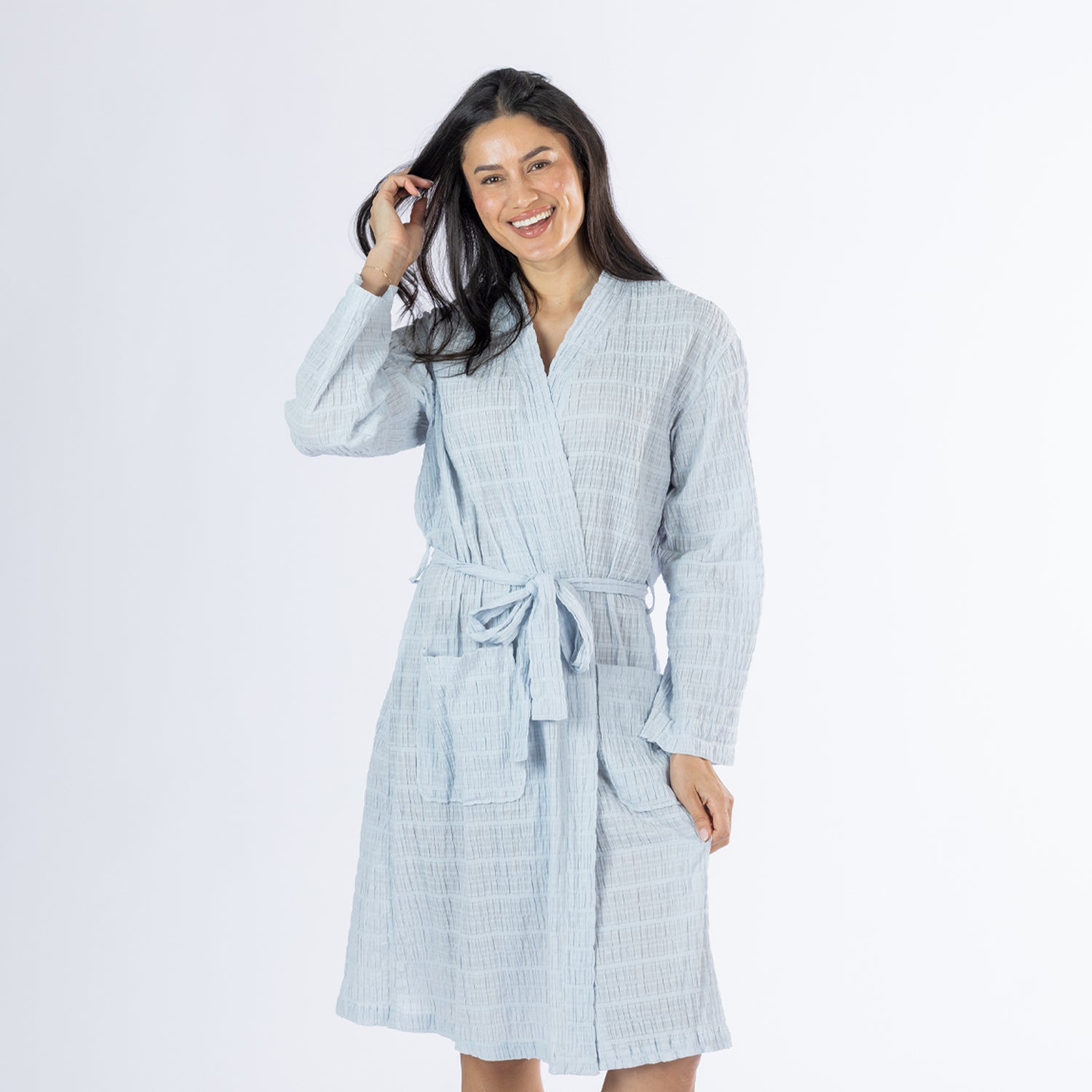Mid-length front view of a model wearing the pale blue textured stripe robe, showing the wrap neckline, tie belt and front patch pockets.