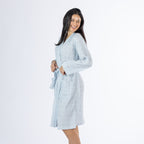 Three-quarter side view of a model wearing the pale blue textured stripe robe, highlighting the relaxed fit, long sleeves and knee-length design.