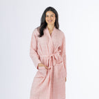 Mid-length front view of a model wearing the pink textured stripe robe, showing the wrap neckline, waist tie and front pocket detail.