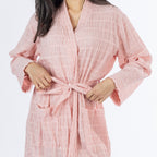 Close-up of the pink textured stripe robe showing the lightweight crinkled texture, wrap front, tie belt and patch pockets.