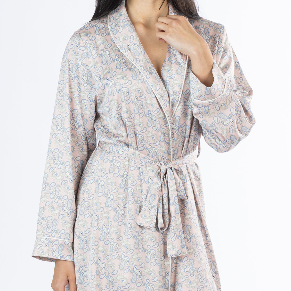 Close-up of the Amparo Cassie Satin Print Bathrobe in Pink, highlighting the detailed paisley pattern, shawl collar, white piping, long sleeves and matching waist tie.