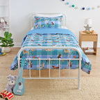 Kids blue animal print duvet cover set styled on a white metal bed in a neutral bedroom.