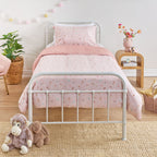 Kids floral print duvet cover set with small scattered flowers and leaves styled on a white metal bed in a neutral bedroom.