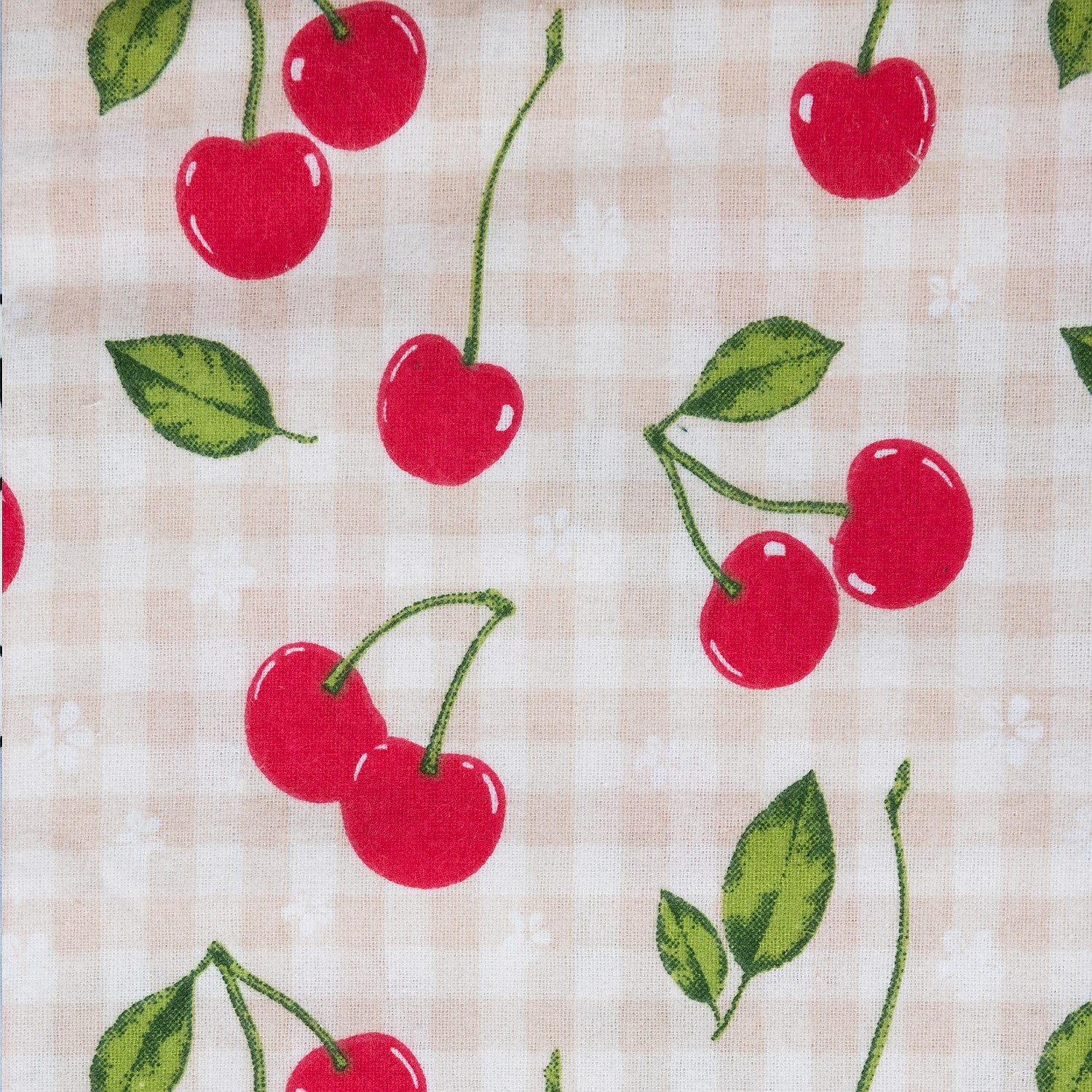 Cherry print fabric with red cherries and green leaves on a pink and white background.