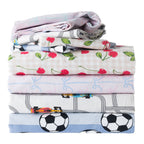 Folded kids duvet cover sets stacked together with cherry, soccer, cars, and bow designs.