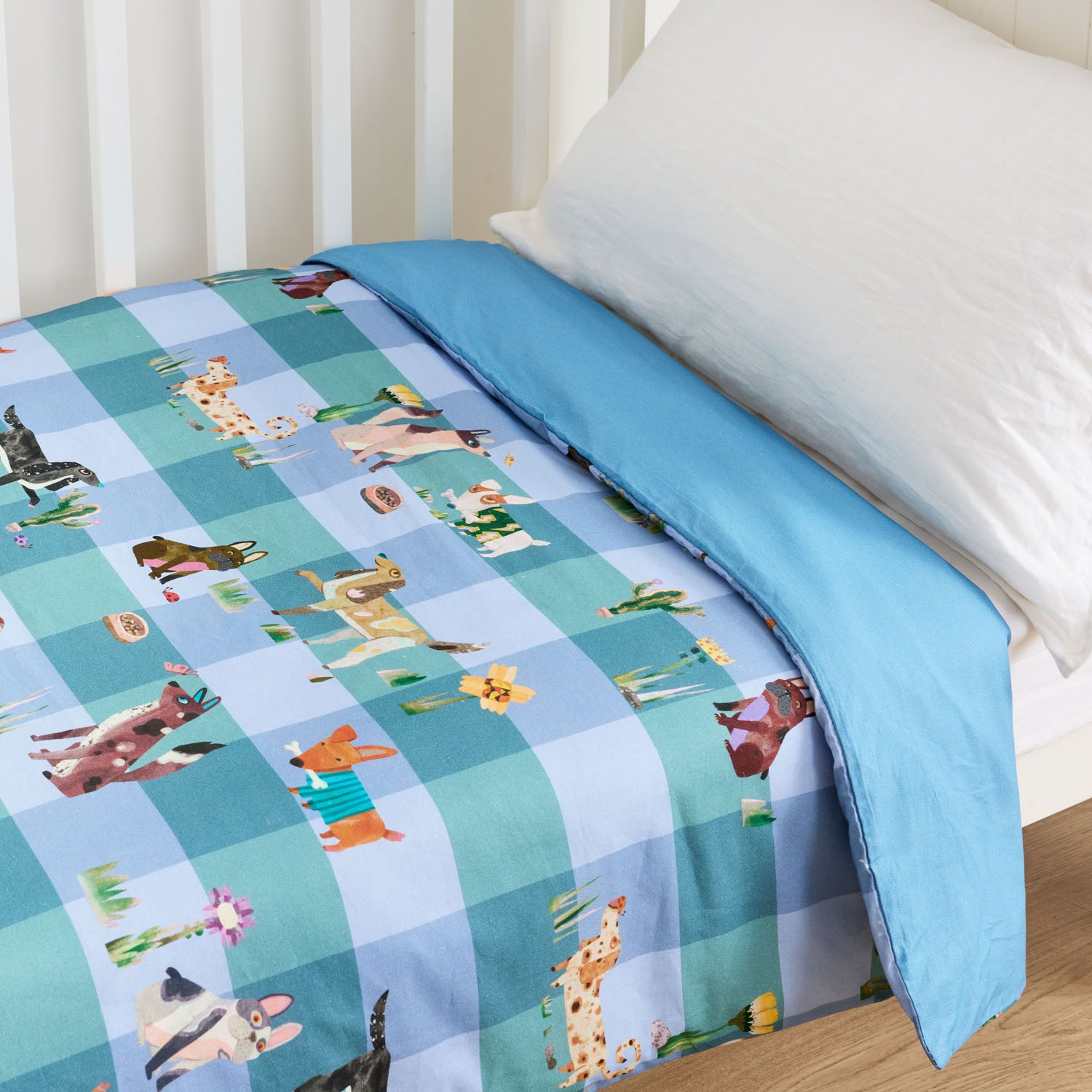 Blue kids animal print cot duvet with illustrated animals on a striped background.