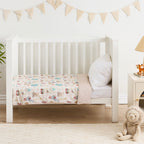 Baby cot styled with a carnival pattern and white pillow in a neutral nursery room.
