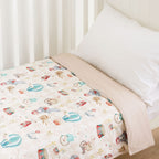 Baby cot styled with a carnival pattern and white pillow in a neutral nursery room.