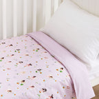 Baby cot styled with a pale pink fairy print cot sheet with a white pillow