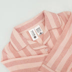 close up of pink striped flannelette pyjamas on a white background showing the tag and caution label