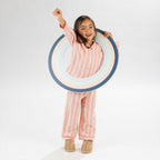 Child wearing pink striped flannelette pyjamas on a white background.