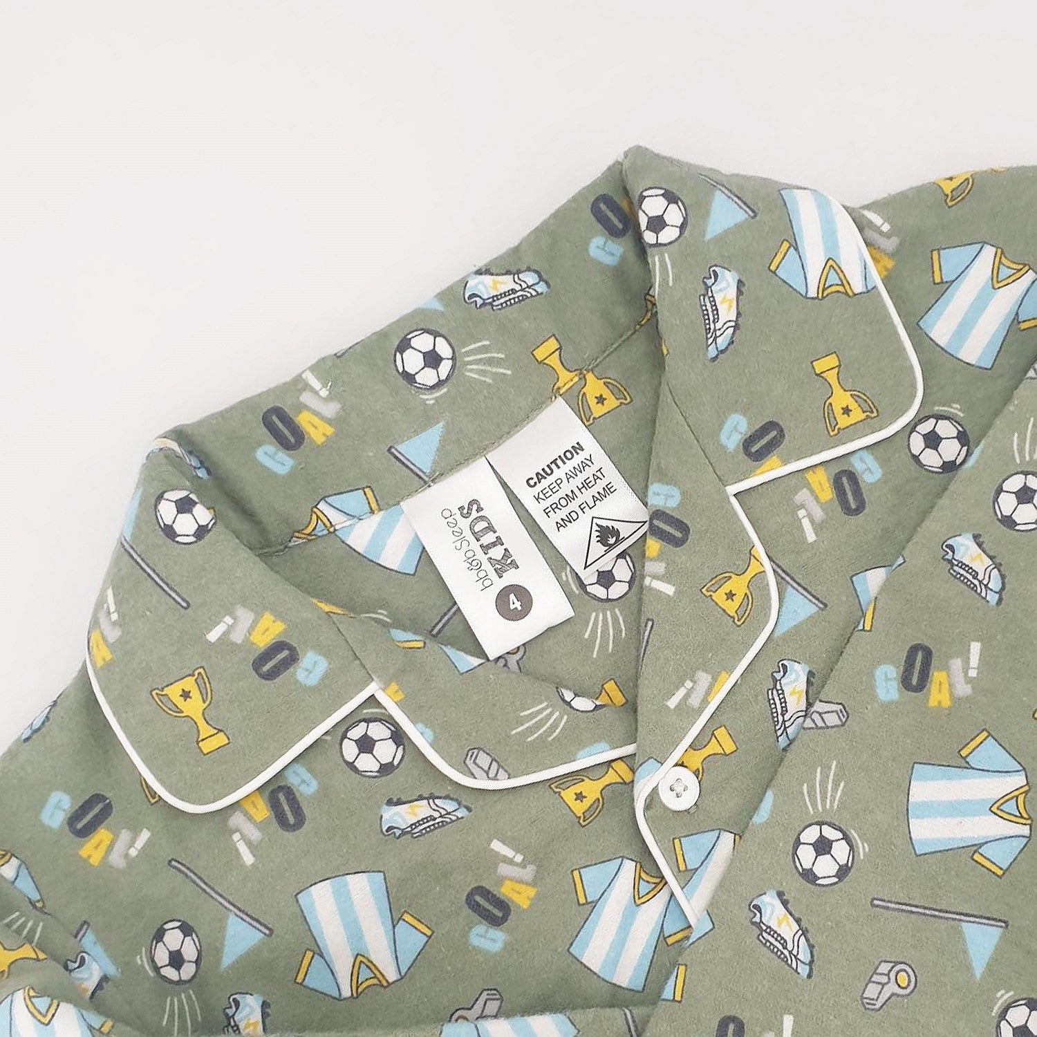 green soccer print pyjamas up close with the tag and caution label shwoing