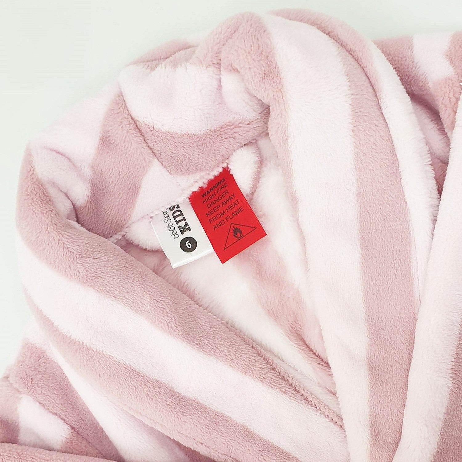 pink striped robe up close showing the tag and warning label 