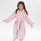 Child wearing a pink striped robe standing on a white background.