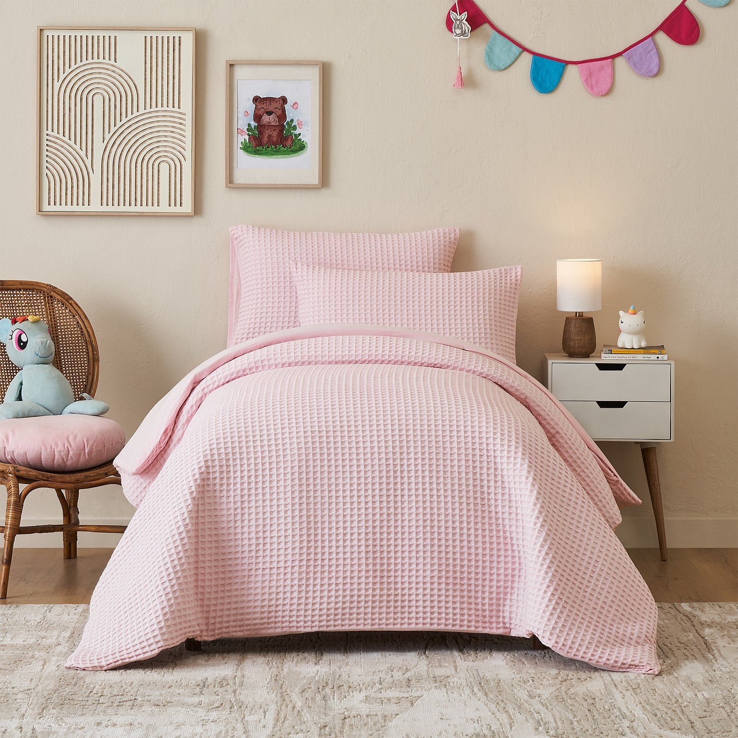 Light pink duvet cover set styled on a bed in a neutral bedroom.