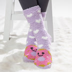 Purple kids bed socks with pink donuts with face design, worn on a soft white rug.