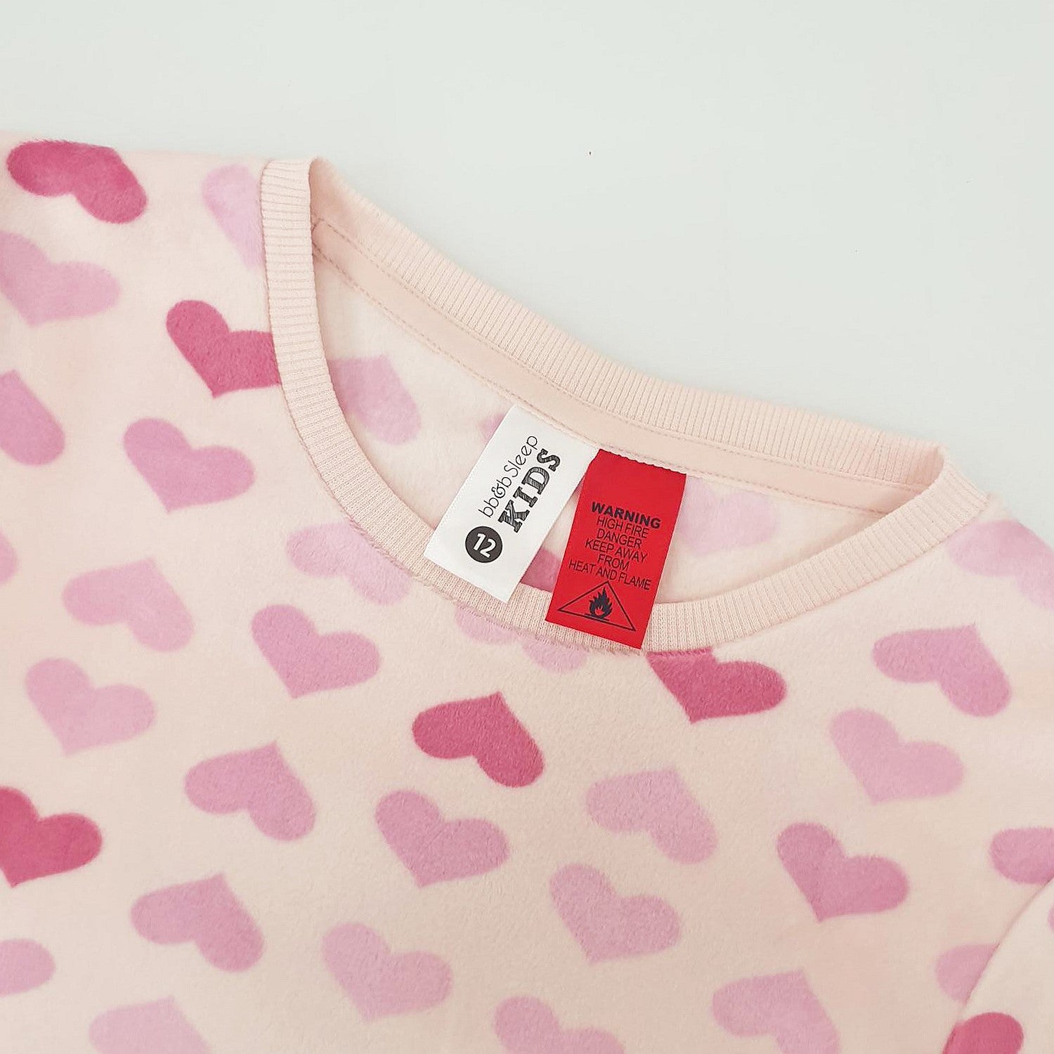 pink heart print pyjamas with the red warning label and tag