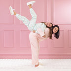 children and adult wearing cosy pyjamas, against a pink background.
