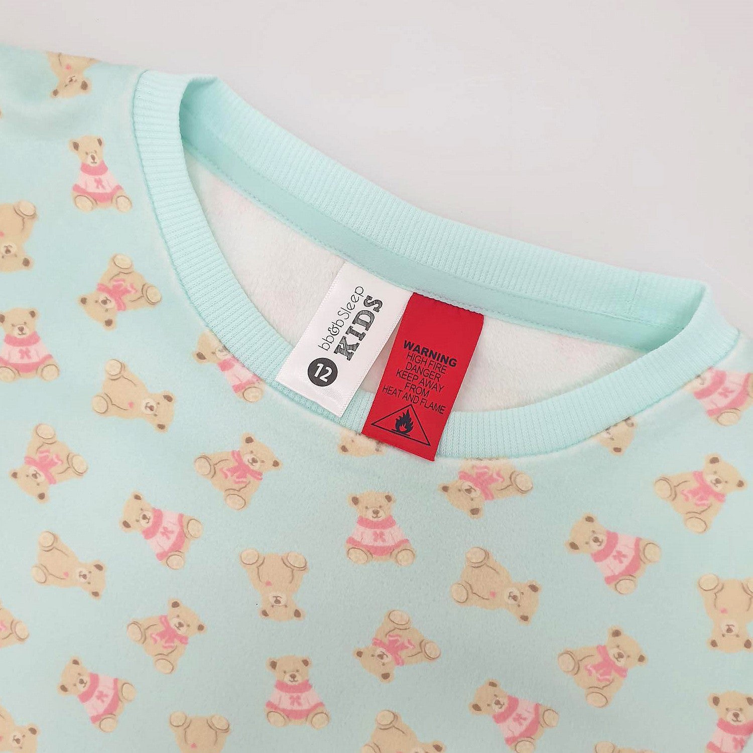 light green teddy printed pyjamas close up with the tag and warning label showing 