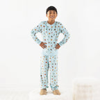 Child wearing light blue space printed pyjamas on a white background.