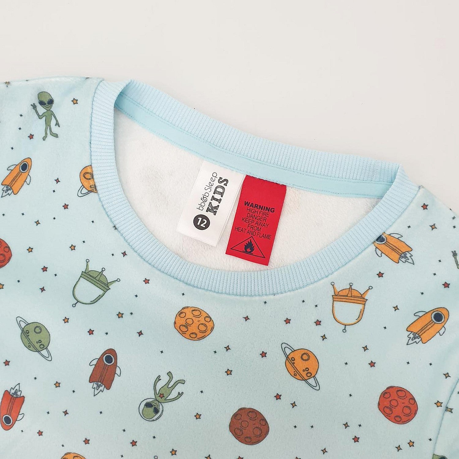 light blue space printed pyjamas with the tag and warning label showing 