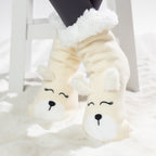 Cream puppy slipper socks with soft fleece lining worn on a white rug.