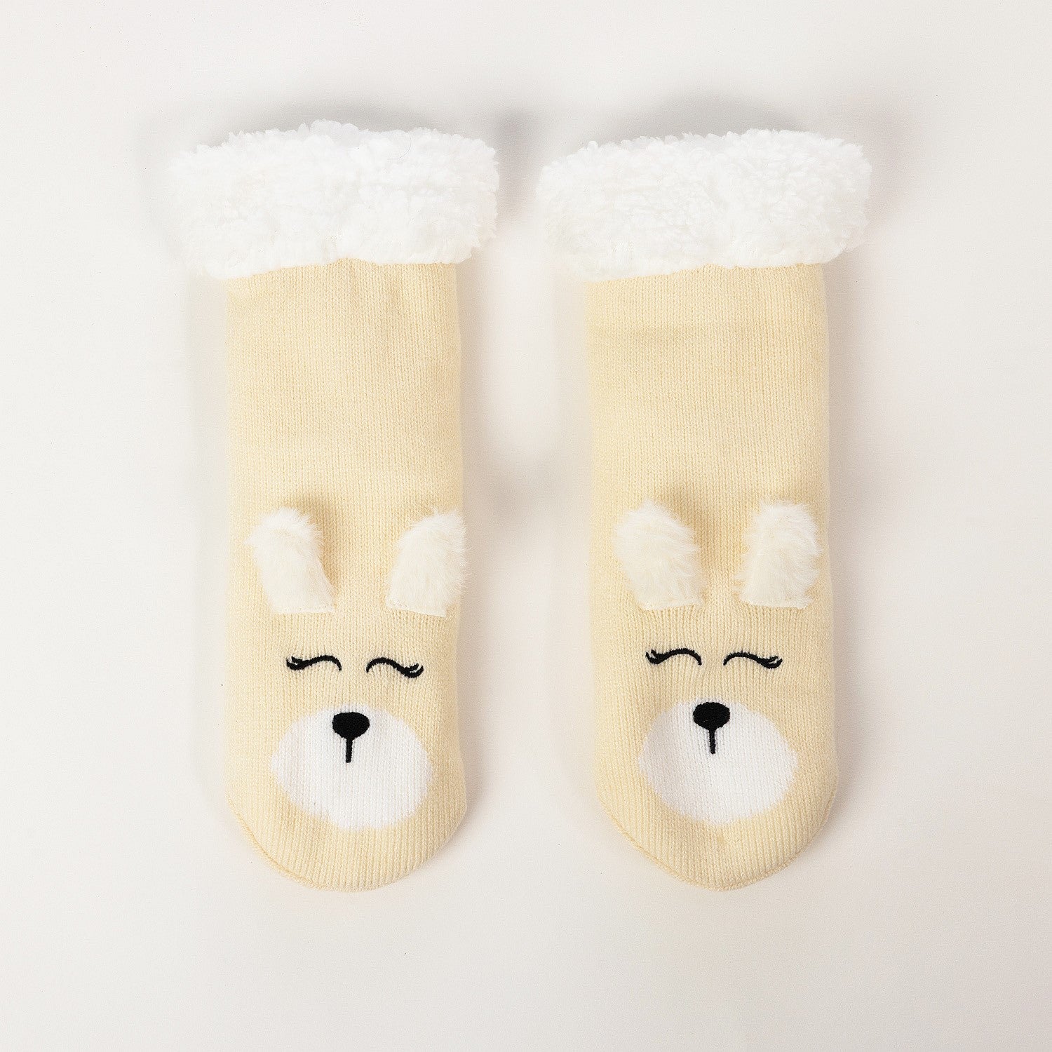 Cream puppy slipper socks with soft fleece lining on a white background