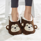Brown monkey slipper socks with soft fleece lining worn on a white rug.