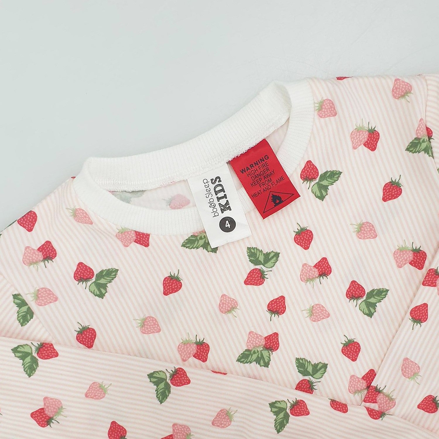 pink and red heart print pyjamas with the tag and warning label showing.