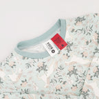 a light green printed pyjama set with unicorns on a white background. With the warning tags
