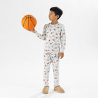 bb&b Sleep Kids Dino Sport knit pyjama twosie worn by a child holding a basketball.