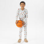 bb&b Sleep Kids Dino Sport knit pyjama twosie worn by a child holding a basketball.