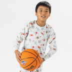 close up bb&b Sleep Kids Dino Sport knit pyjama twosie worn by a child holding a basketball.