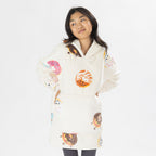 Child wearing a white oversized hoodie with colourful donut playful print on a white background.