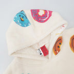 white oversized hoodie hood with colourful donut playful print on a white background.