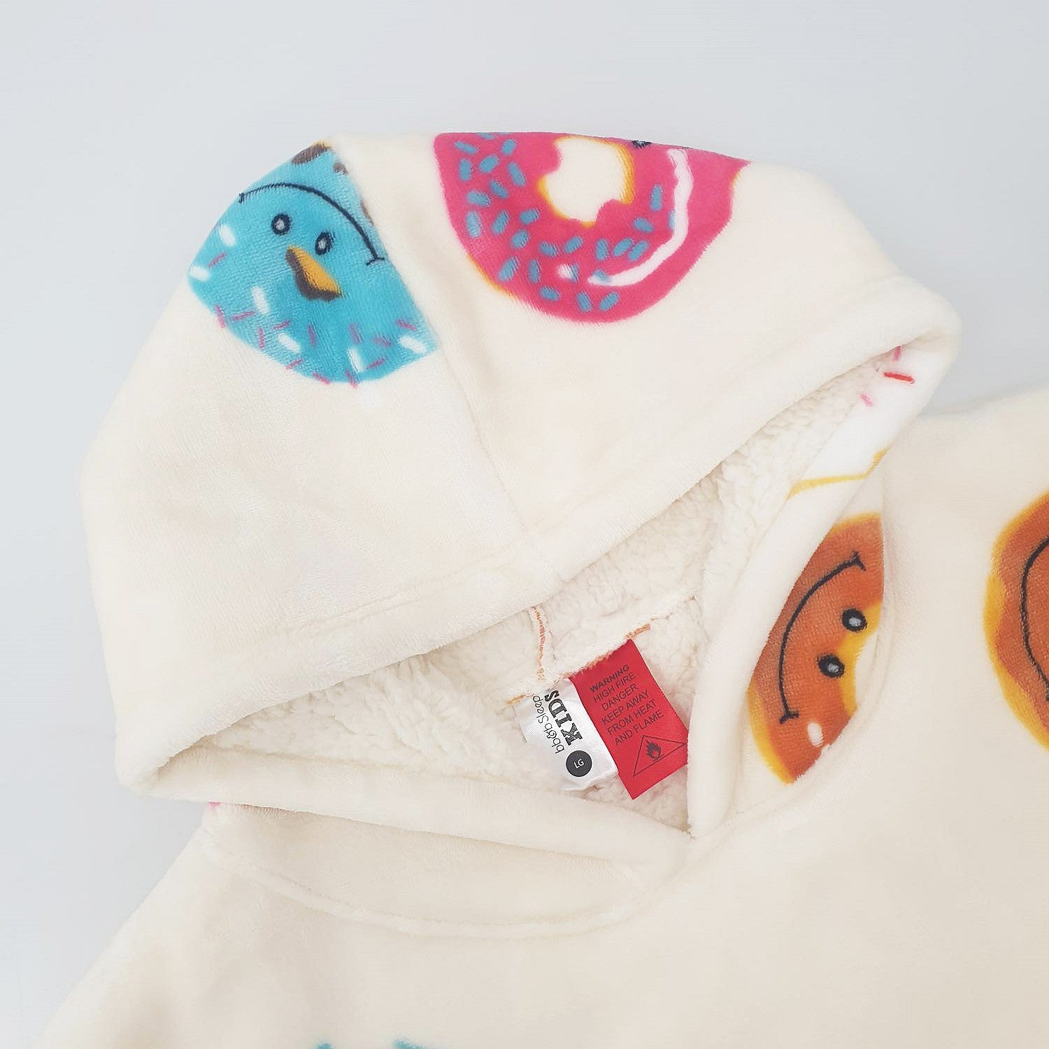 white oversized hoodie hood with colourful donut playful print on a white background.
