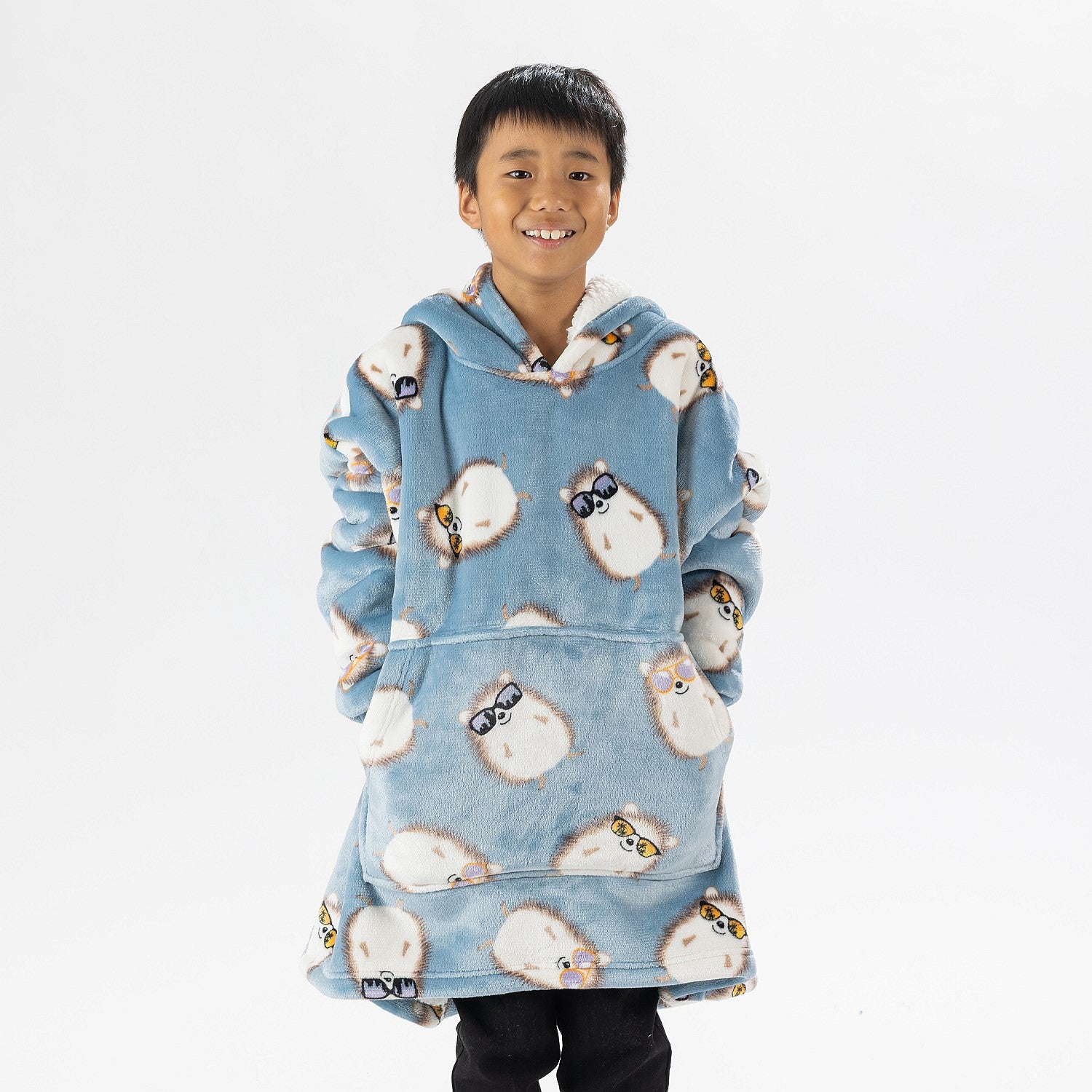 Child wearing a blue hedgehog print oversized hoodie with a cosy hood and front pocket.