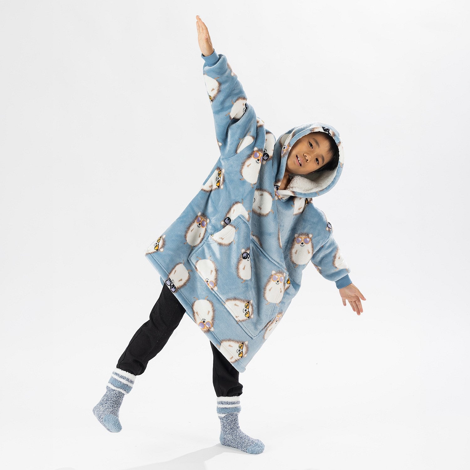 Child wearing a blue hedgehog print oversized hoodie with a cosy hood and front pocket.