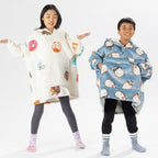 Two children wearing oversized printed hoodies, one in cream and one in blue, standing on a white background.