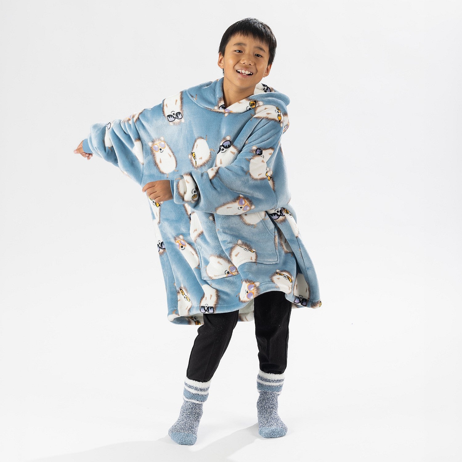 Child wearing a blue hedgehog print oversized hoodie with a cosy hood and front pocket.