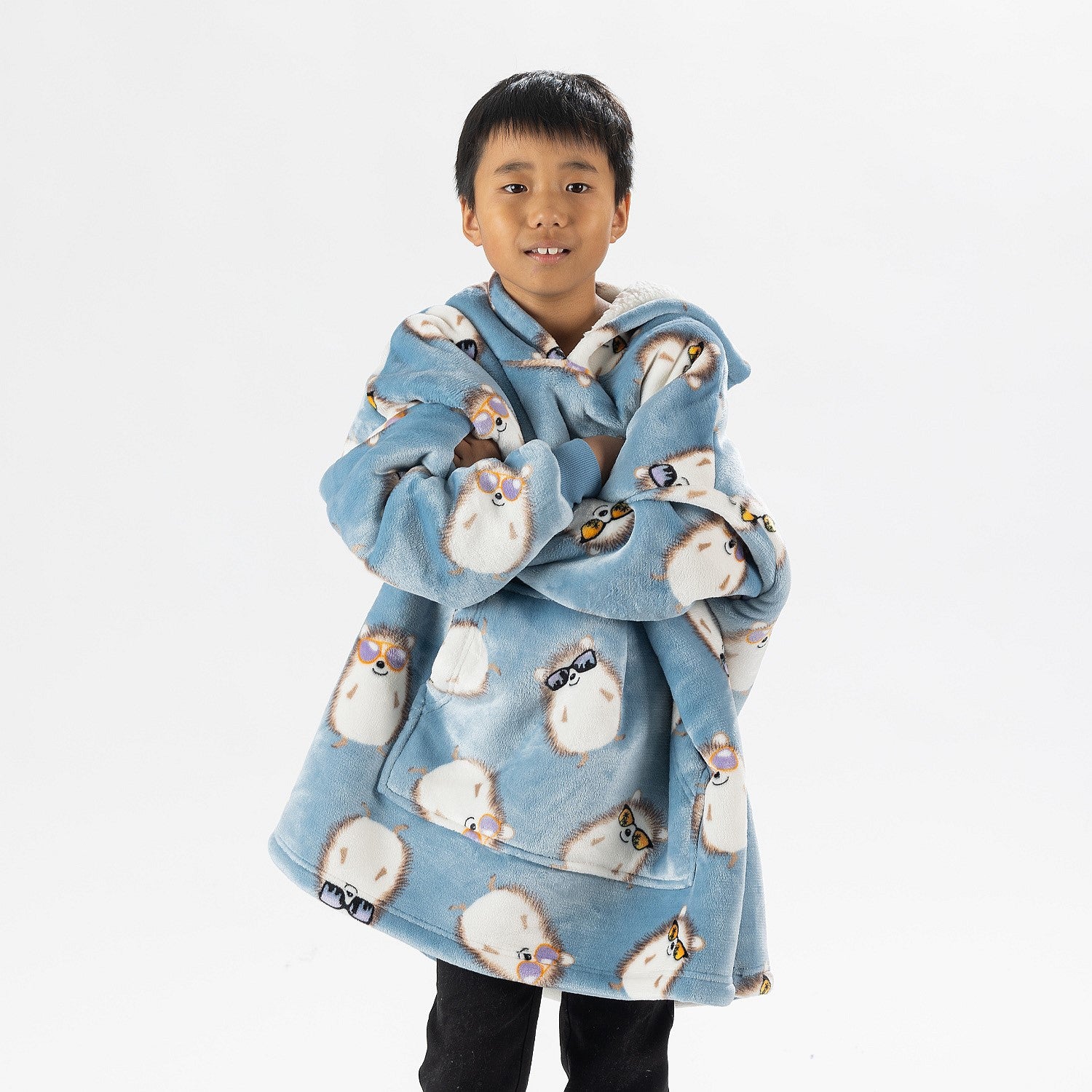 Child wearing a blue hedgehog print oversized hoodie with a cosy hood and front pocket.