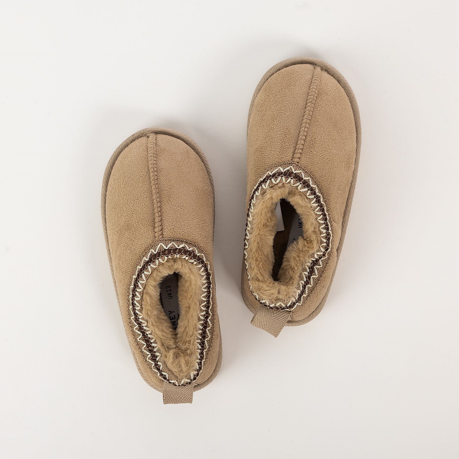 Tan faux fur slippers with soft lining on a white background.