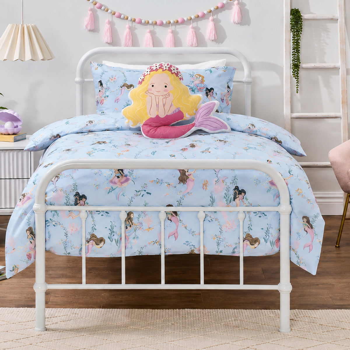 bb&b Kids Mermaid Dreams duvet cover set styled on a white metal bed, featuring a light blue mermaid and underwater print with a coordinating pillowcase and mermaid-shaped cushion.