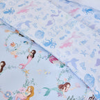 Close-up of the bb&b Kids Mermaid Dreams duvet cover set showing the light blue mermaid print alongside a coordinating pillowcase with shells, octopus, dolphins and underwater motifs.