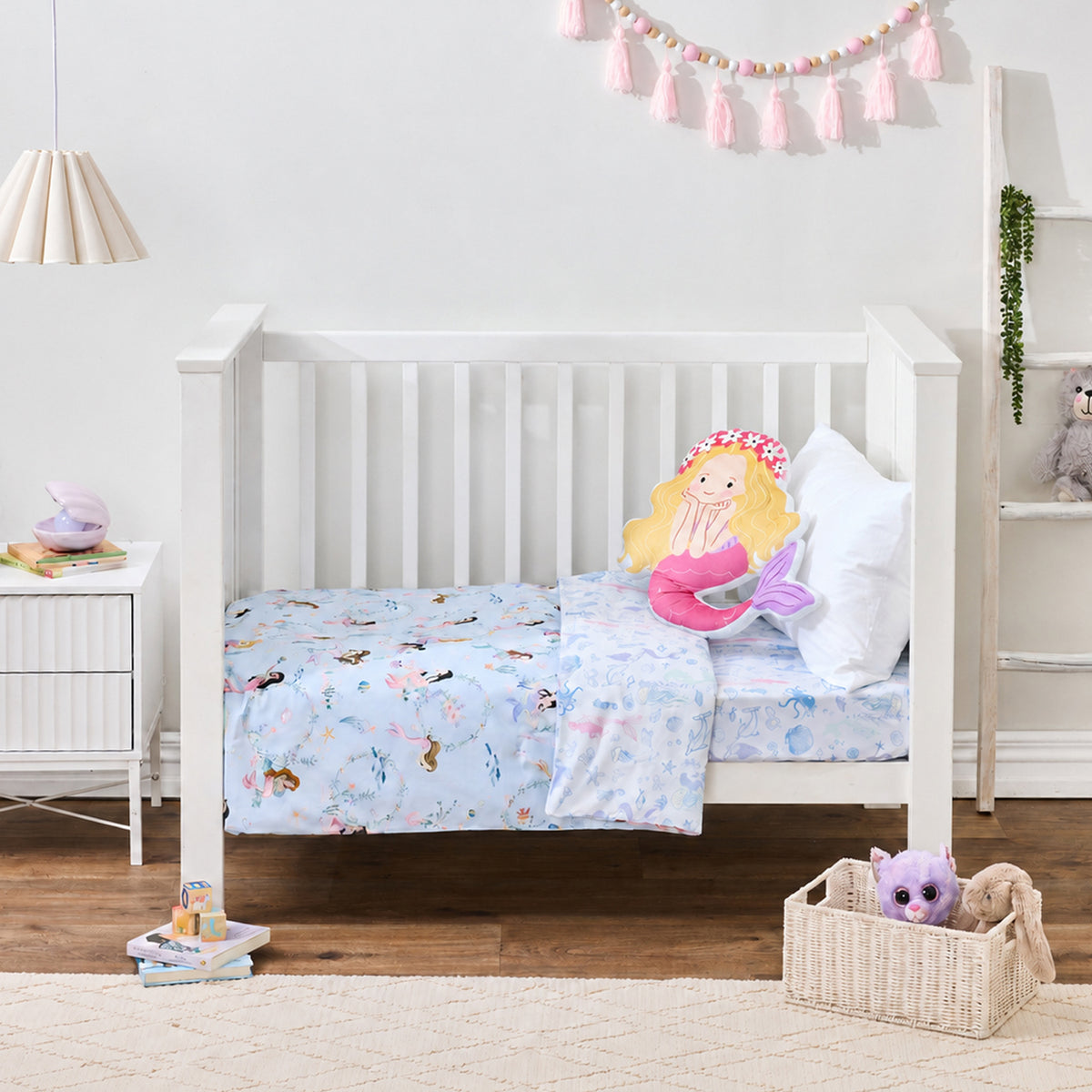 bb&b Kids Mermaid Dreams cot styled with a light blue mermaid-themed cot cover, finished with a mermaid-shaped cushion and white pillow.