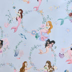 Close-up of the bb&b Kids Mermaid Dreams print on a light blue background, featuring colourful mermaids, flowers, coral, fish and underwater motifs.